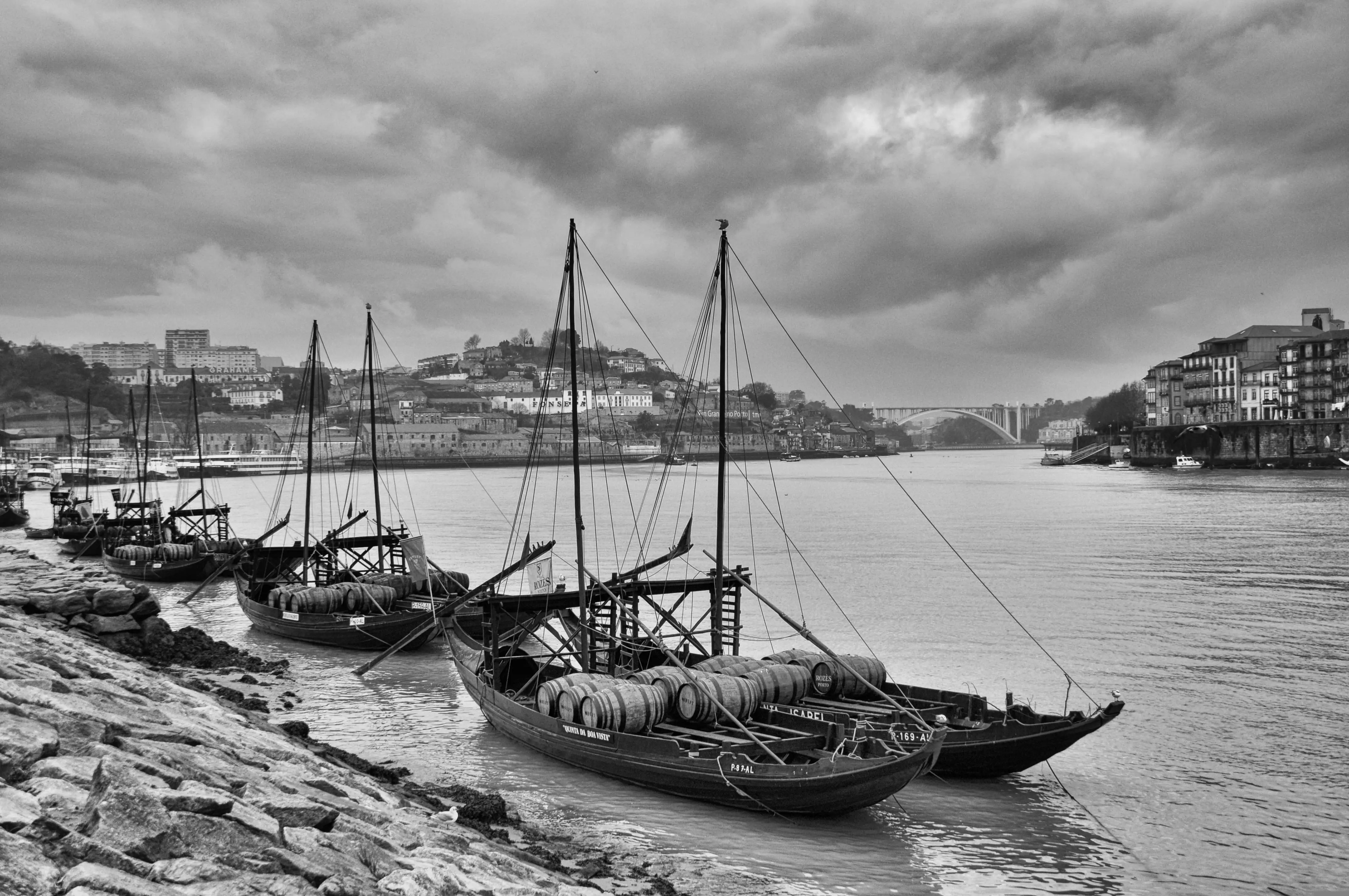 Imagem a preto e branco de barcos rabelos no rio